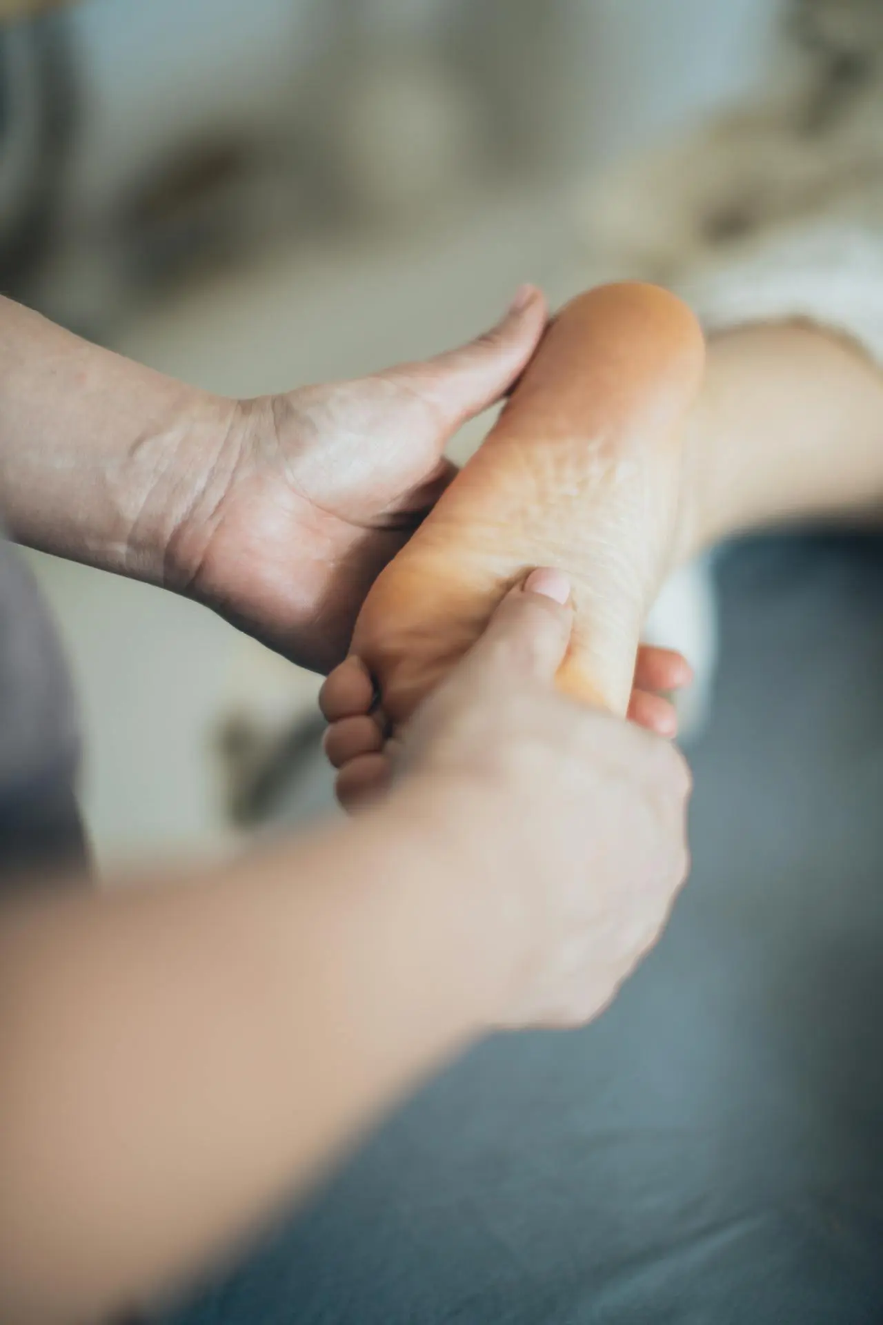 Reflexologist applying pressure to a client's foot during a treatment session